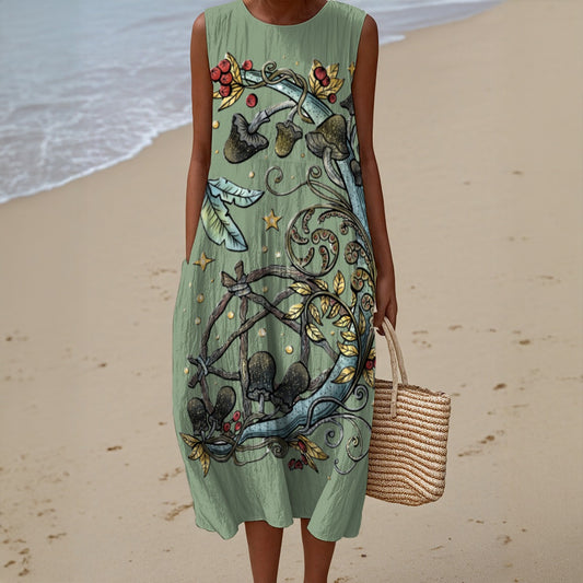 Person wearing a green sleeveless dress with floral patterns on a beach.