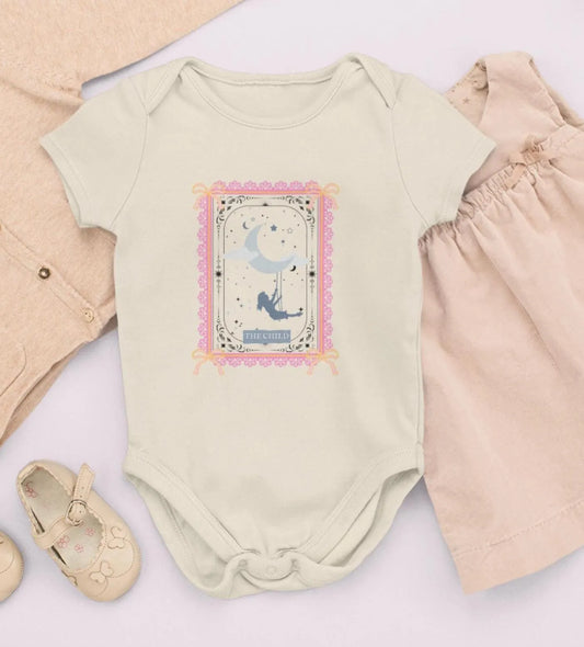 Baby outfit with a onesie, pants, and shoes on a light background