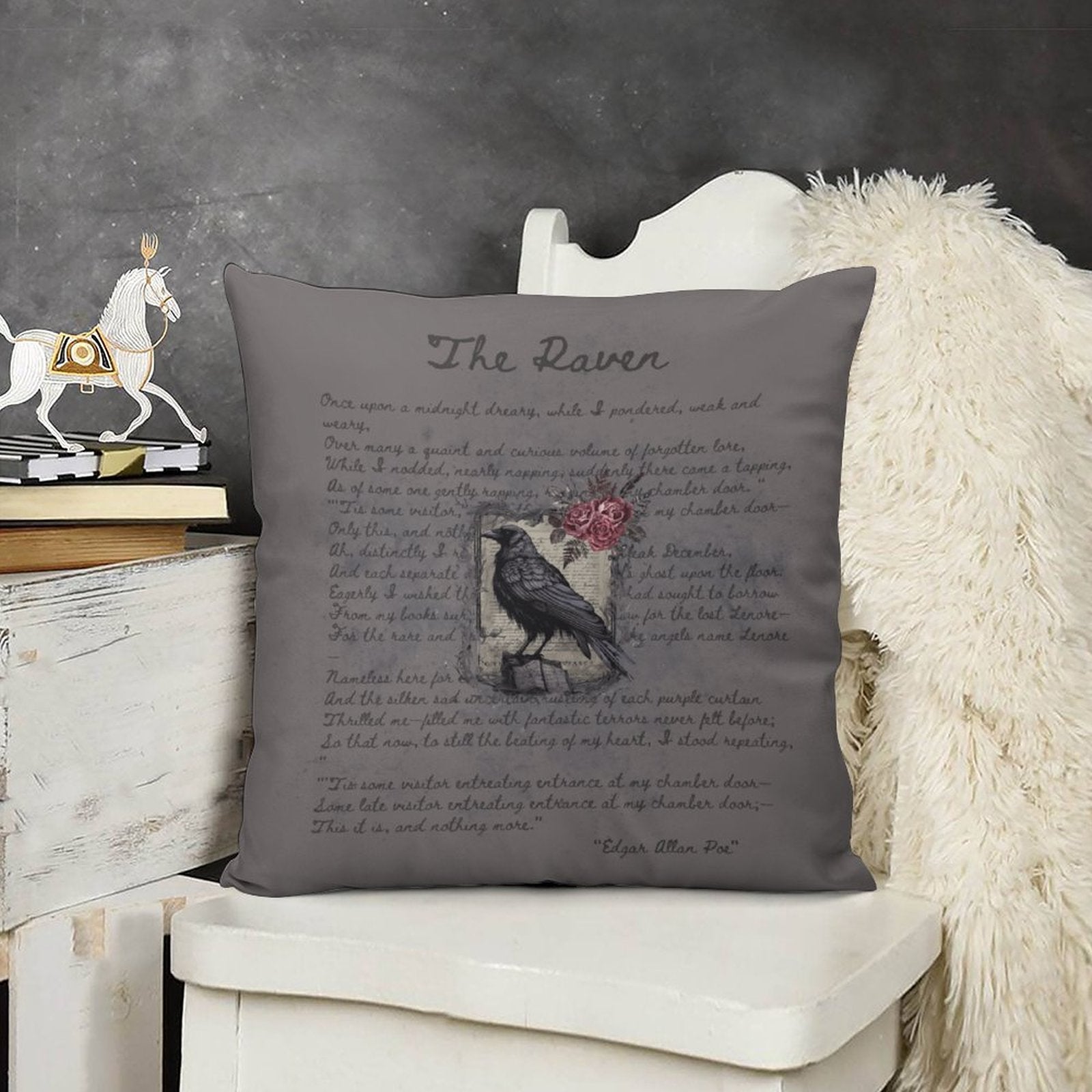 Decorative pillow with a crow and rose design and text on a chair against a dark background