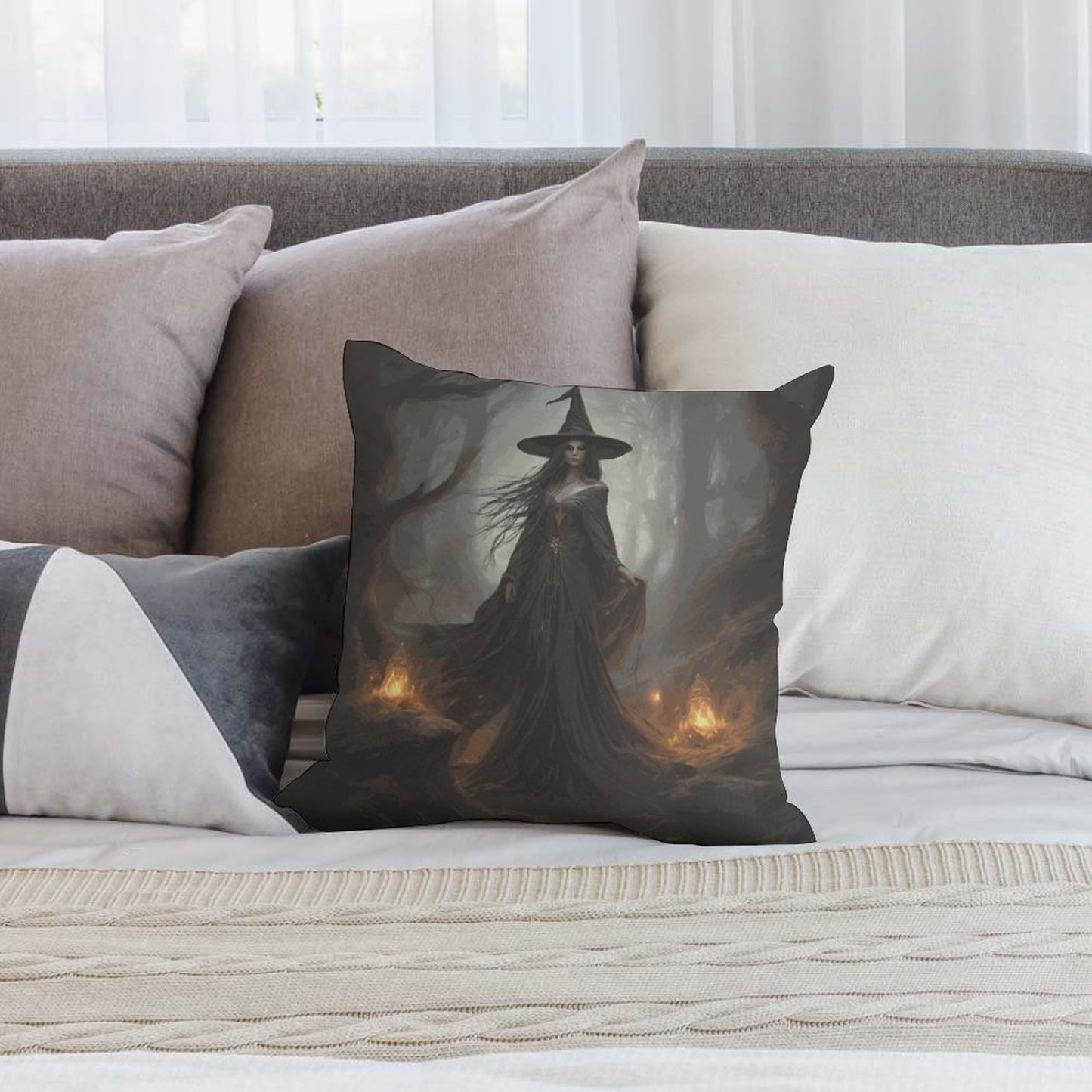 Decorative pillow with a witch design on a sofa with neutral-colored pillows.