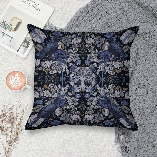 Decorative pillow with floral and bird pattern on a surface with a book and cup of coffee.