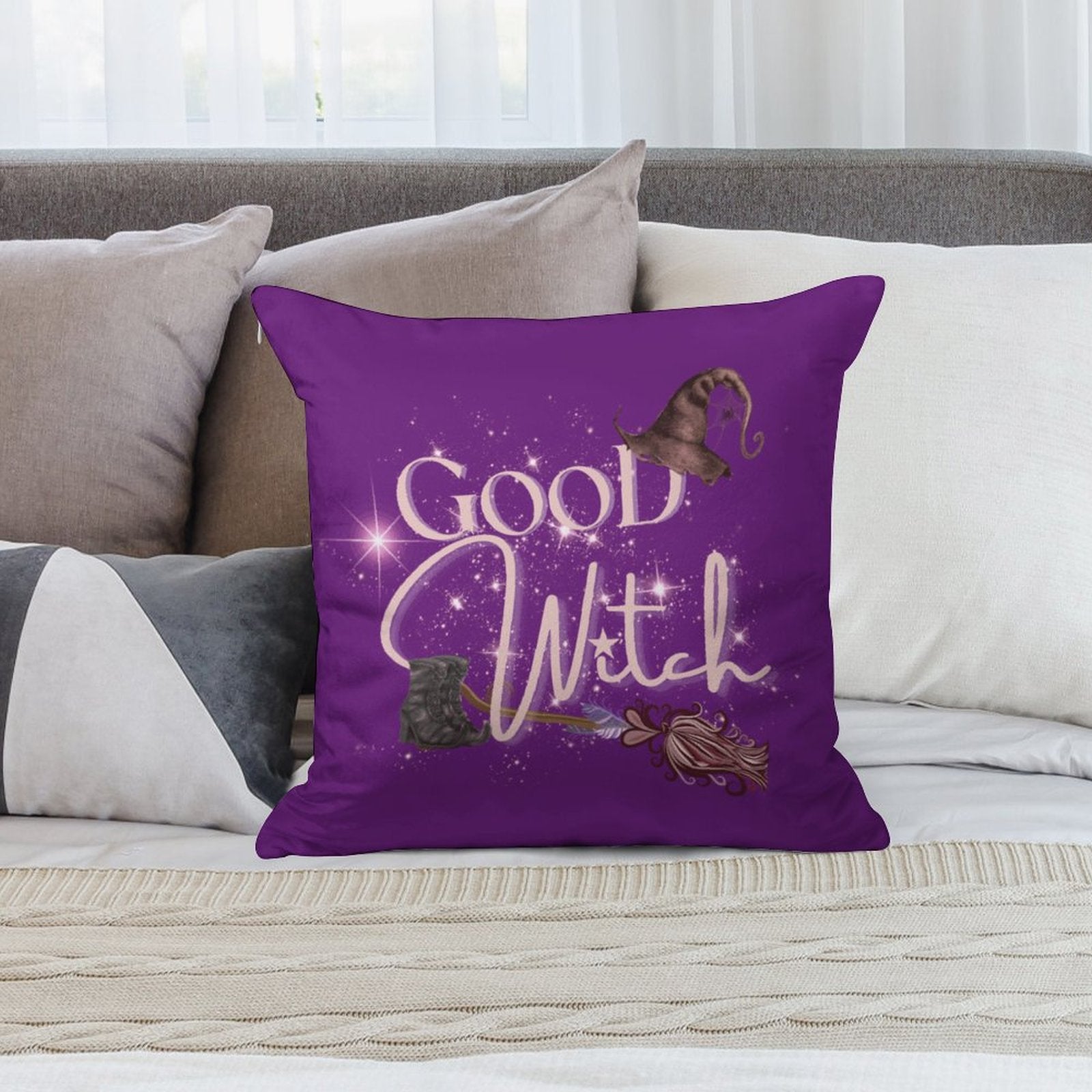 Purple pillow with 'Good Witch' text and witch hat design on a couch.