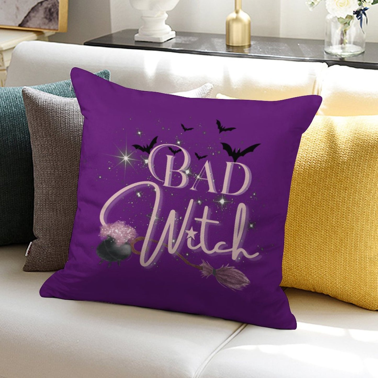 Purple pillow with 'Bad Witch' text on a couch