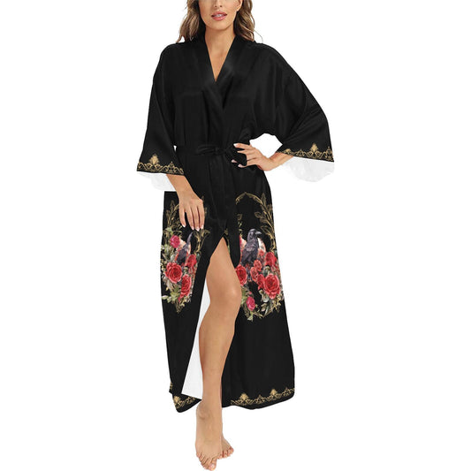 Woman wearing a black robe with floral and bird embroidery on a white background