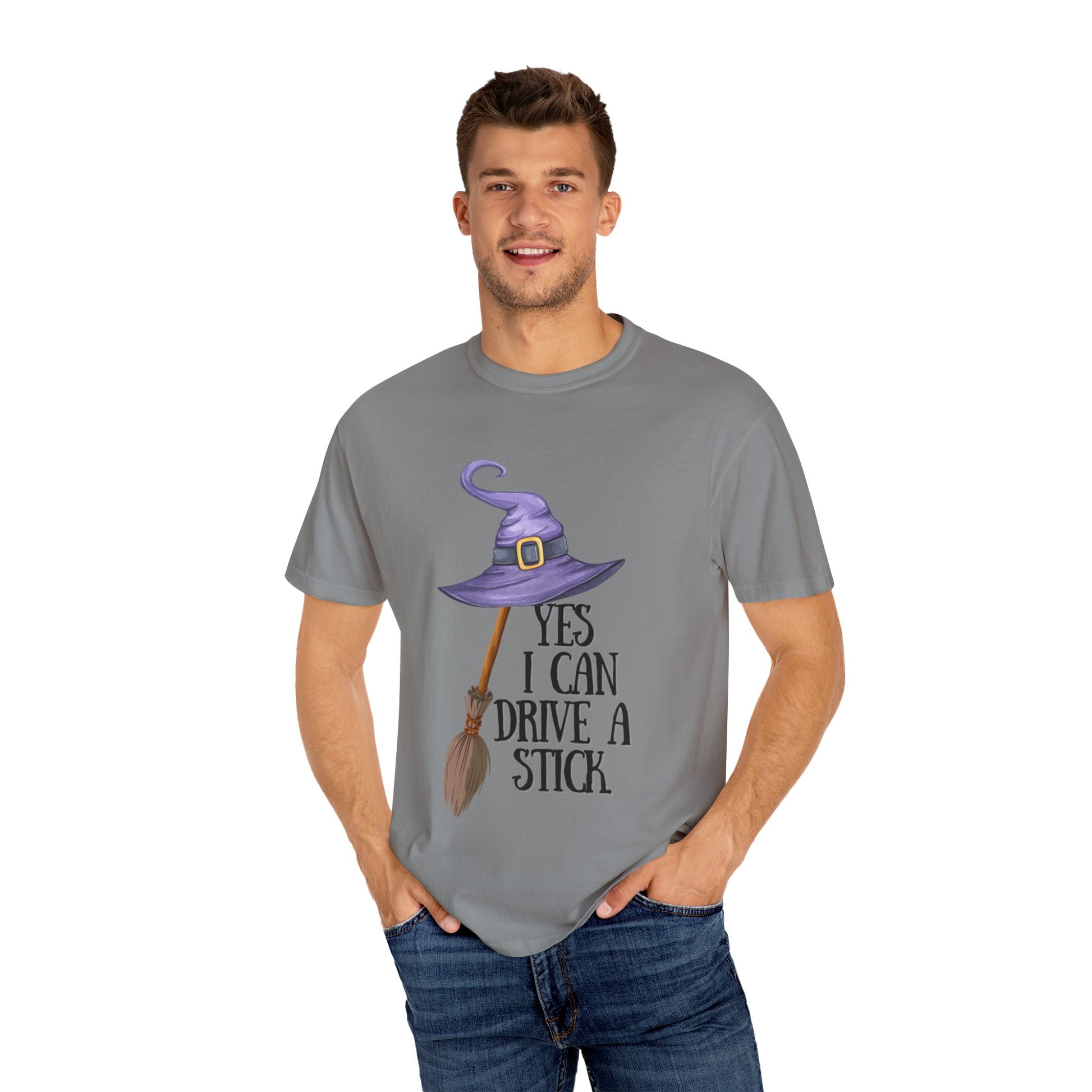 Man wearing a gray t-shirt with a purple witch hat and broomstick graphic and text.