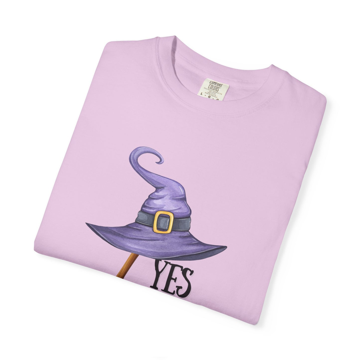 Folded pink t-shirt with a witch hat graphic and 'YES' text on a white background