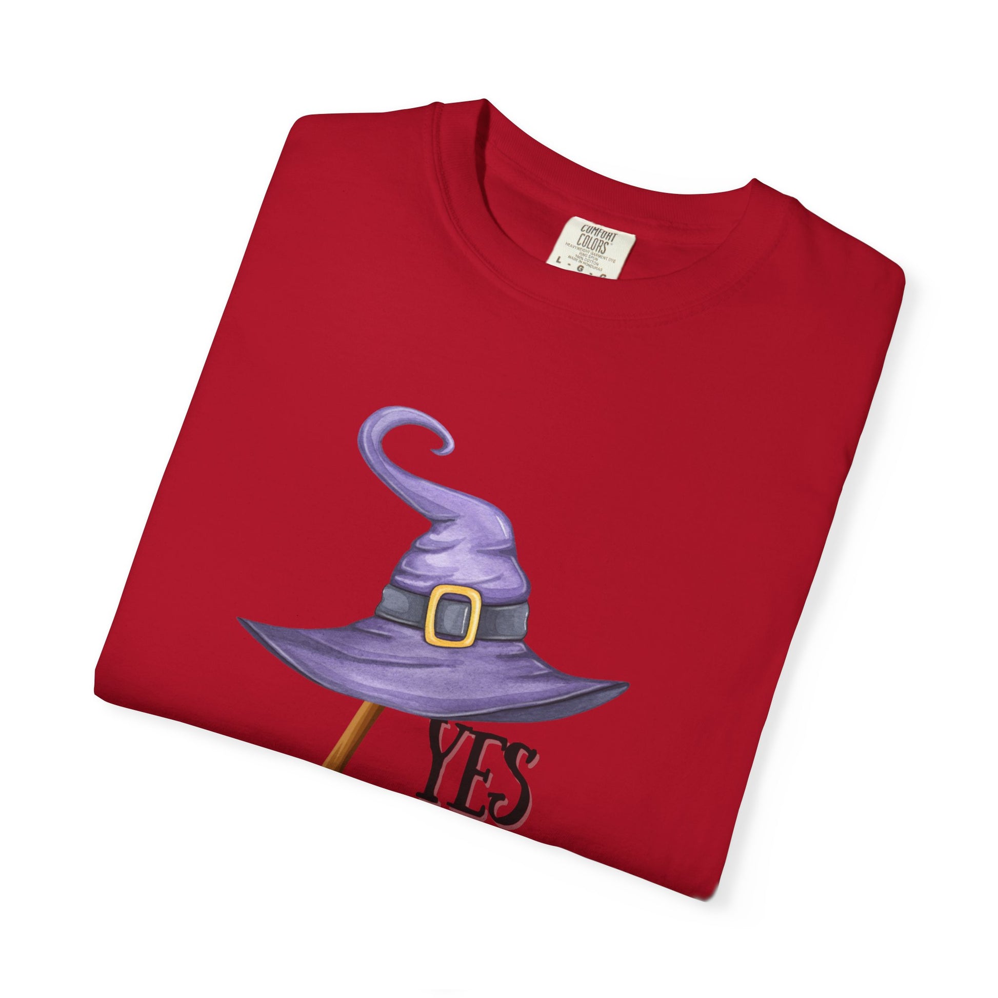 Folded red t-shirt with a purple witch hat and 'YES' text on a white background