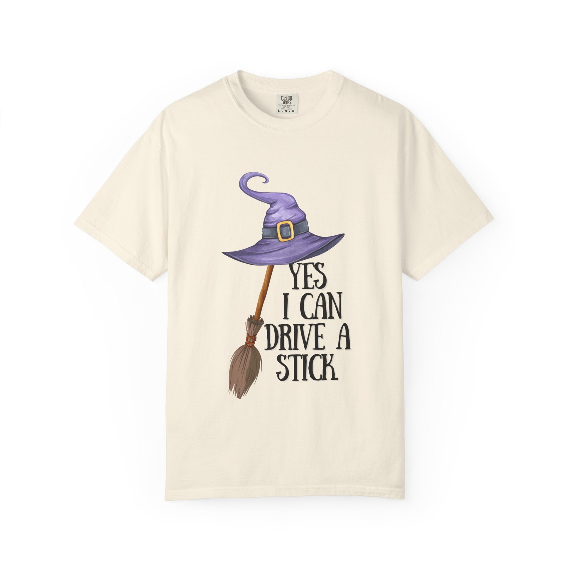 Beige t-shirt with witch hat, broom, and text design on a white background