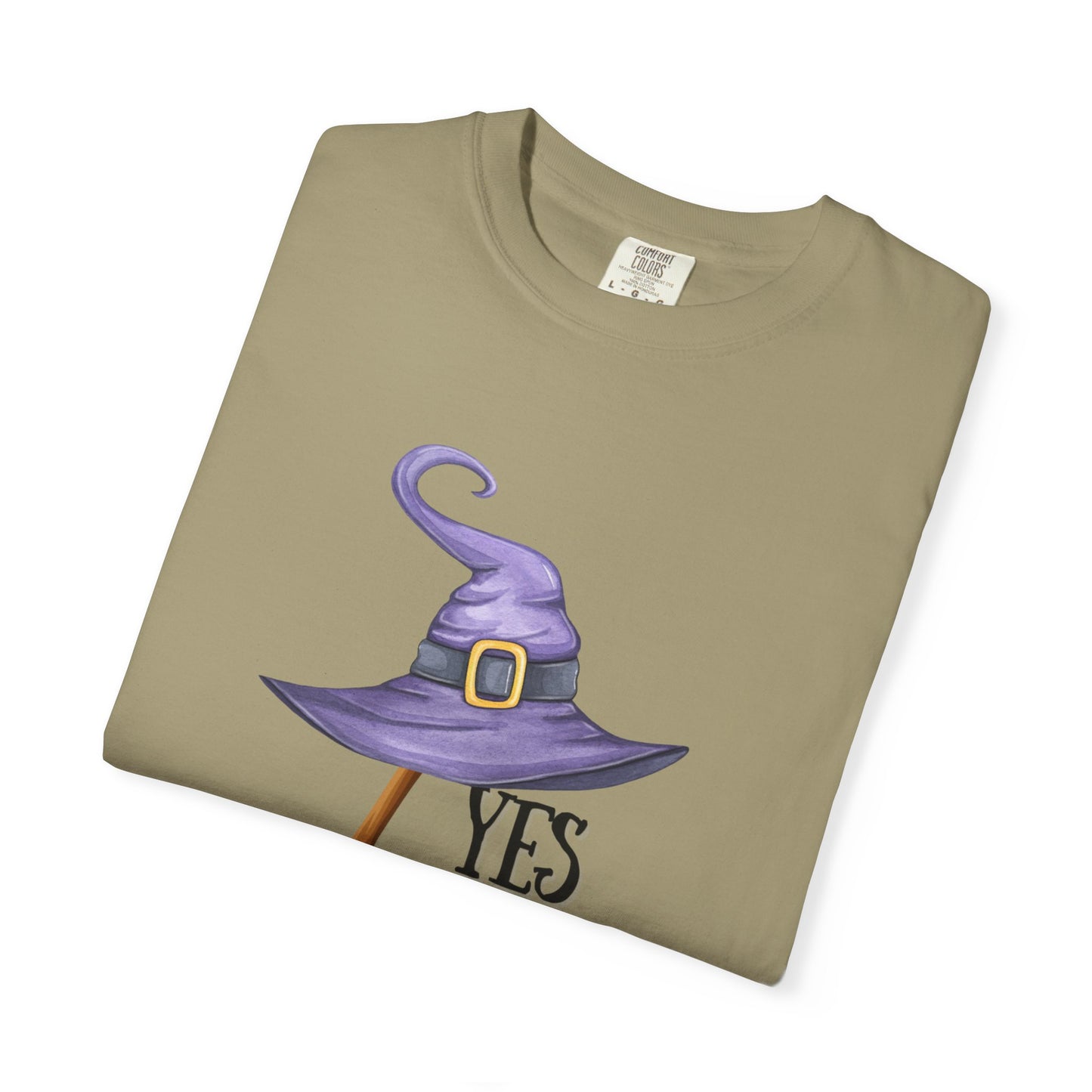 Folded khaki t-shirt with a purple witch hat and 'YES' text on a white background