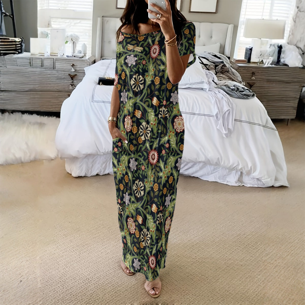 Woman taking a mirror selfie wearing a floral dress in a bedroom.