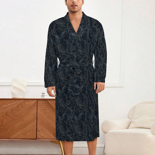 Man wearing a dark patterned robe in a room with a wooden sideboard and white wall.