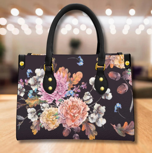 Floral-patterned handbag with black handles on a wooden surface
