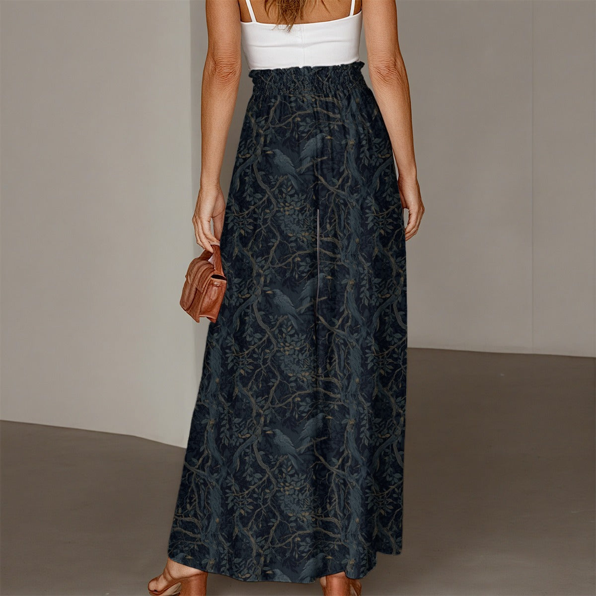 Person wearing a long dark blue patterned skirt with a white top against a neutral background