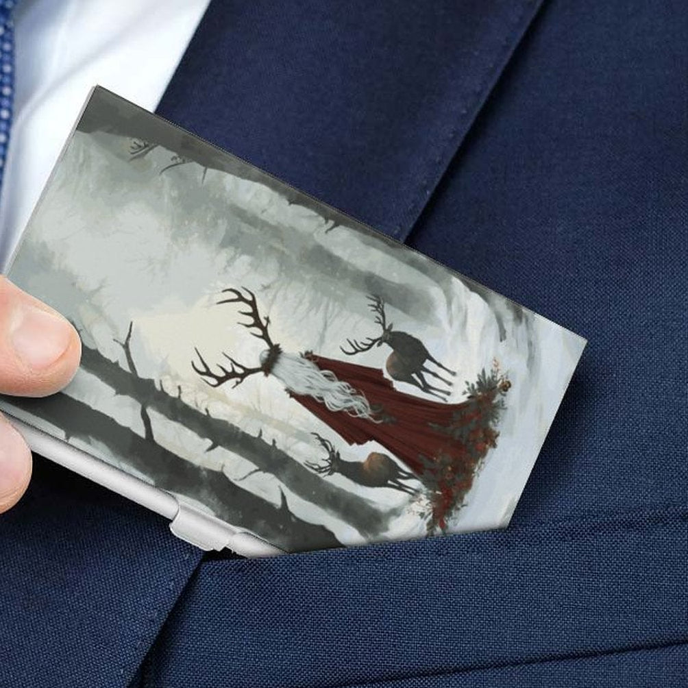 Person in a suit holding a business card case with a nature design.