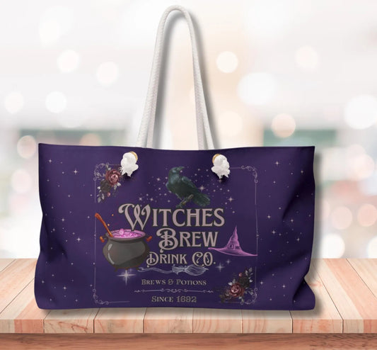 Purple tote bag with 'Witches Brew Drink Co.' design on a wooden surface.