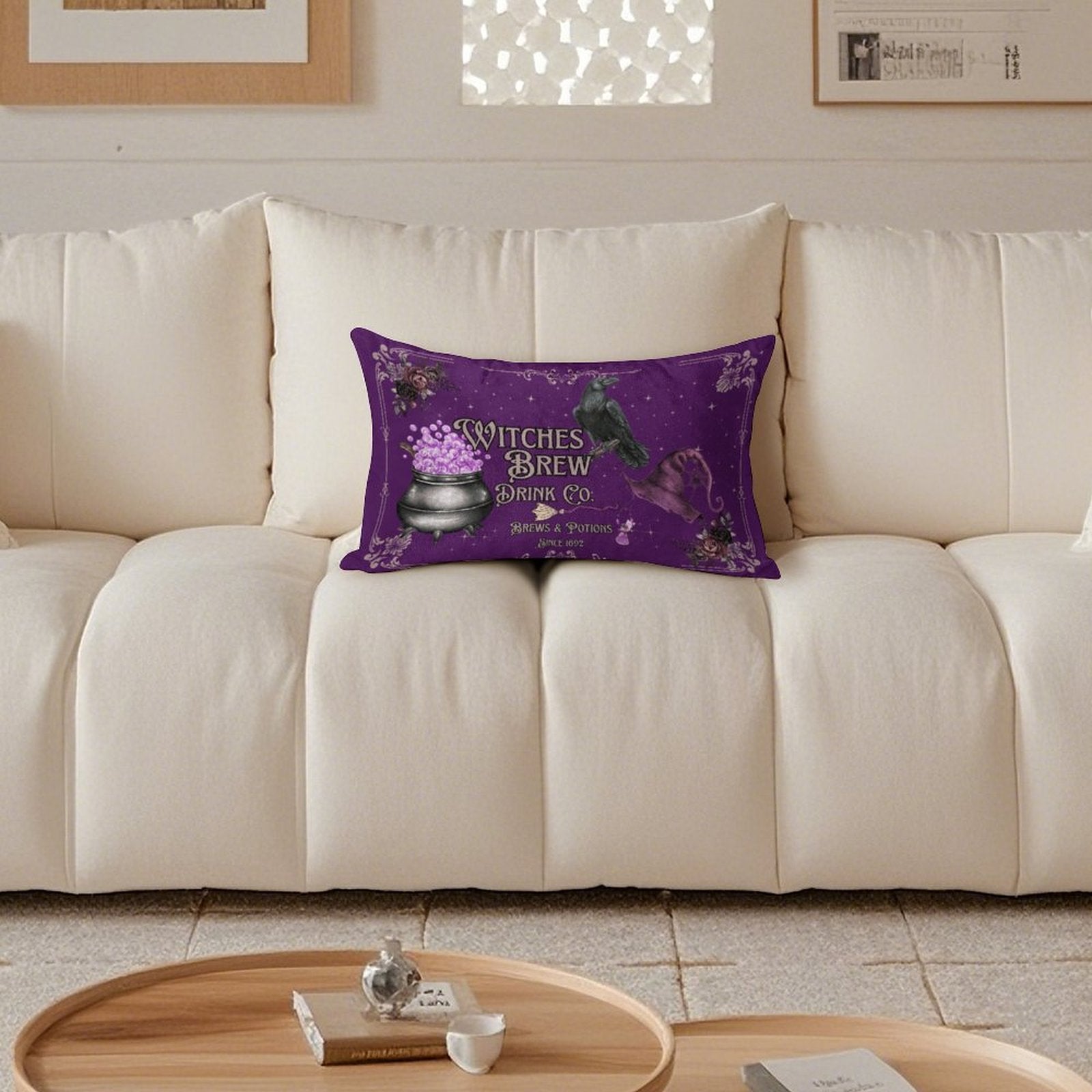 Purple pillow with 'Witches Brew' design on a beige sofa