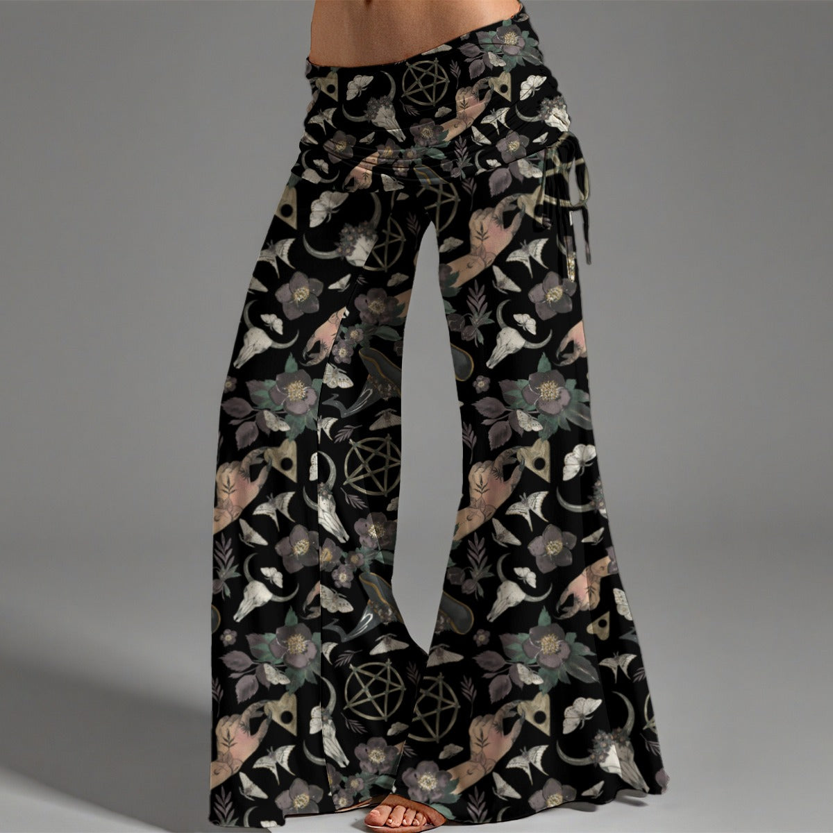 Flared pants with a black background and nature-themed pattern on a gray background