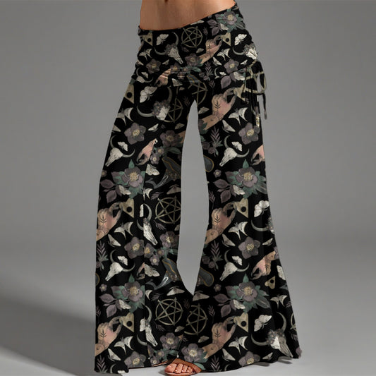 Flared pants with a black background and nature-themed pattern on a gray background