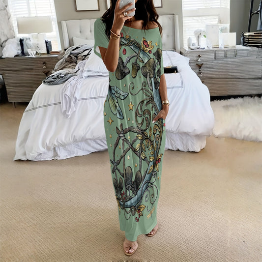 Woman wearing a long, patterned dress in a bedroom setting