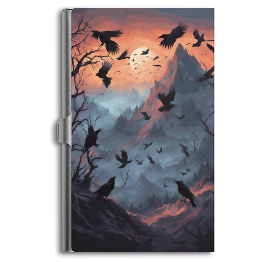 A business card holder with a dark twilight background featuring a flock of crows flying over a hill.
